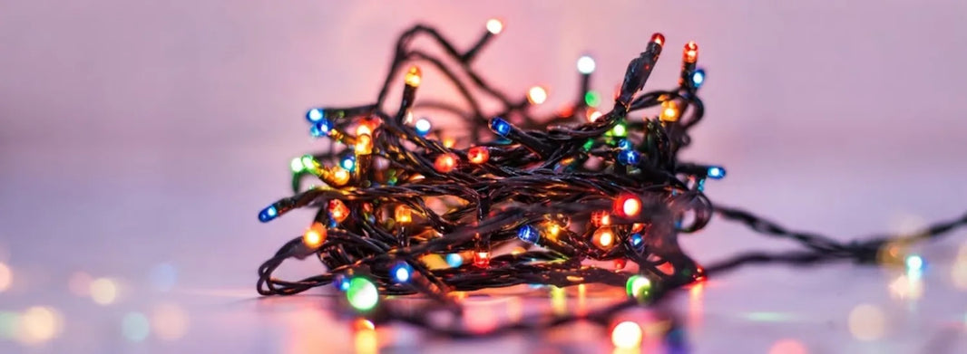 A tangled coil of low-end retail Christmas lights with varying bulb sizes and colors.